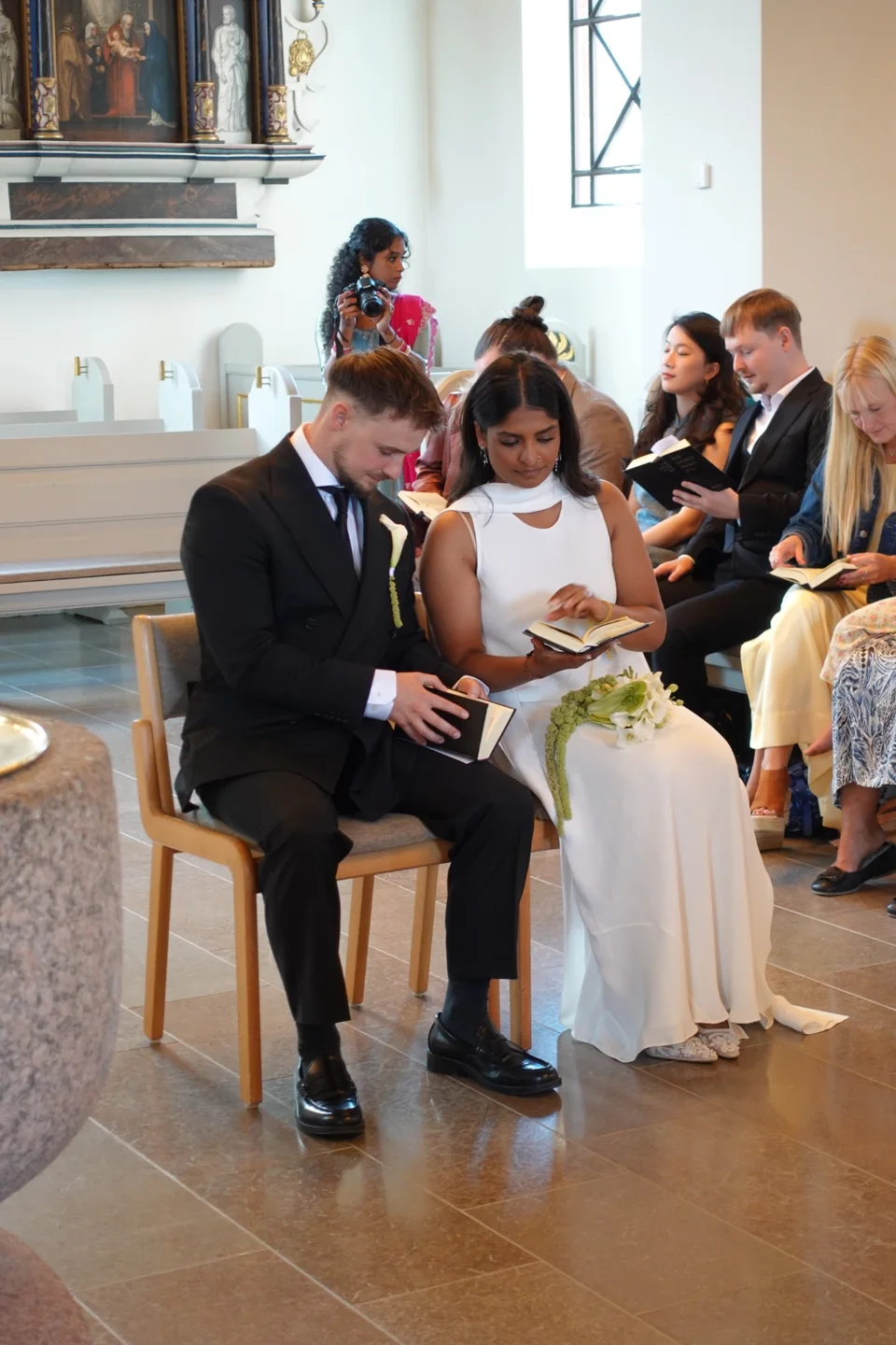A wedding couple seated together during a church ceremony